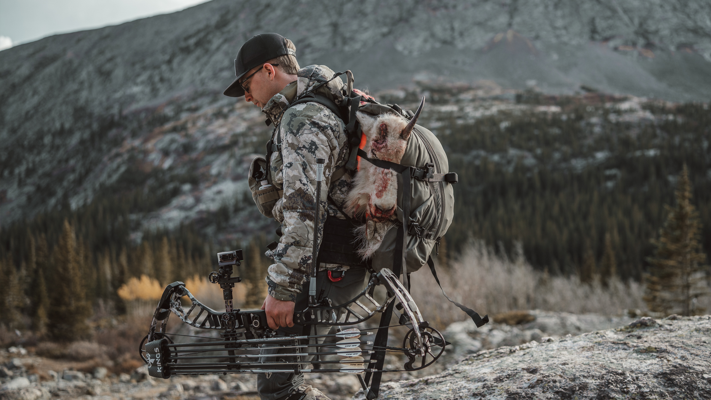 Hunter carrying backpack in the mountains